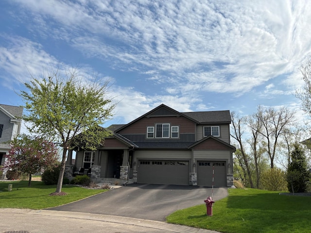 craftsman inspired home with a garage, a front yard, asphalt driveway, stone siding, and covered porch