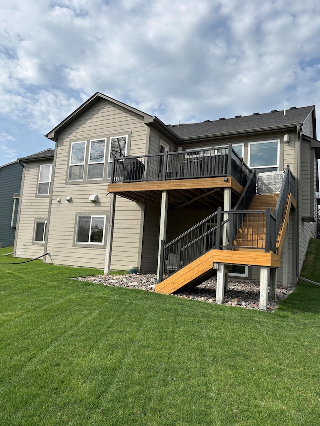 rear view of property with a deck, a yard, and stairway