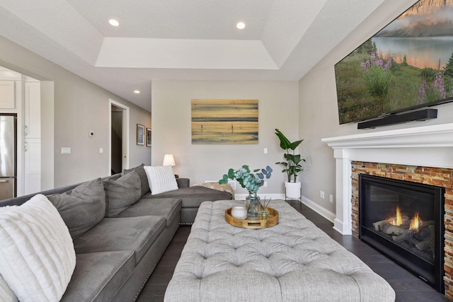3742 Crane Island Ct, Minnetrista, MN 55331 - living room featuring dark wood finished floors, a glass covered fireplace, recessed lighting, a raised ceiling, and baseboards