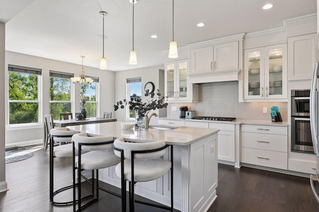 3742 Crane Island Ct, Minnetrista, MN 55331 - kitchen with a sink, light countertops, decorative backsplash, white cabinetry, and dark wood-style flooring