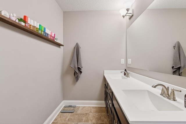 3742 Crane Island Ct, Minnetrista, MN 55331 - bathroom featuring double vanity, baseboards, and a textured ceiling