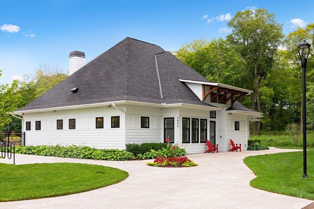 3742 Crane Island Ct, Minnetrista, MN 55331 - back of house featuring a chimney, a lawn, a shingled roof, and a patio area
