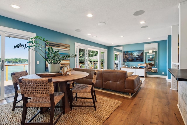 dining area featuring hardwood / wood-style floors, recessed lighting, a textured ceiling, and baseboards