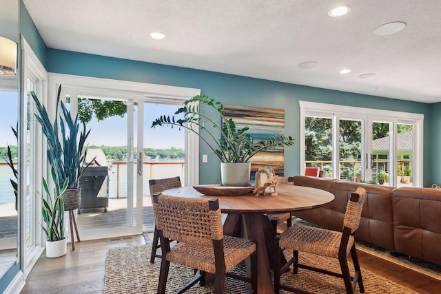 dining area featuring healthy amount of natural light, recessed lighting, french doors, wood finished floors, and a textured ceiling