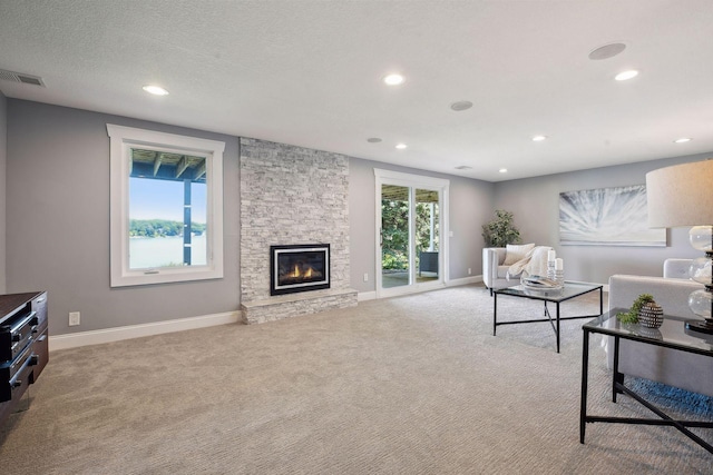 living room with carpet, recessed lighting, a stone fireplace, and baseboards