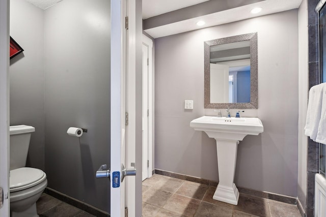 bathroom with toilet, baseboards, and a sink