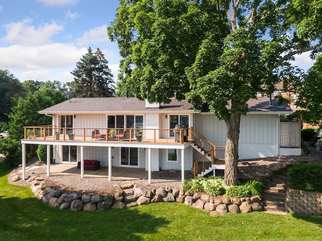back of property with stairway, a patio, a yard, and a deck