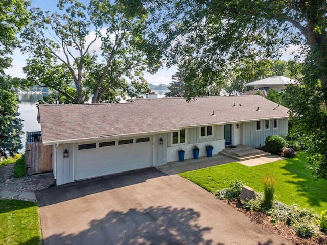 single story home featuring board and batten siding, roof with shingles, a garage, and concrete driveway