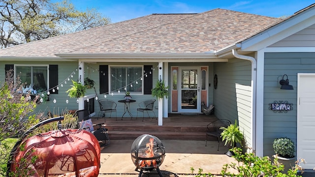 view of exterior entry with a shingled roof