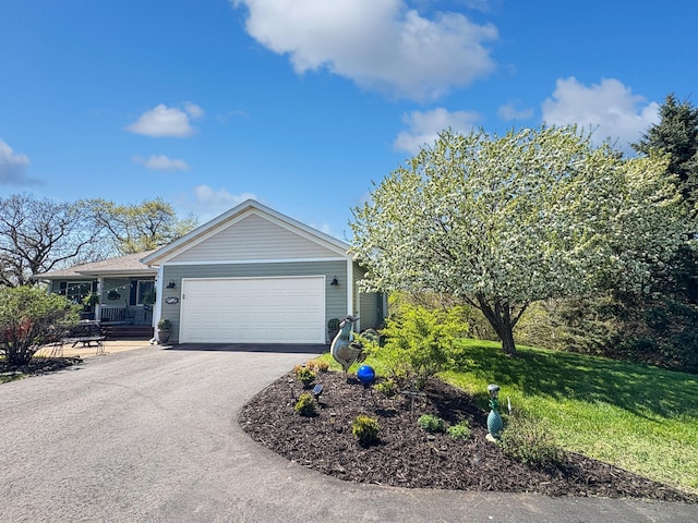 ranch-style house with driveway, an attached garage, and a front yard