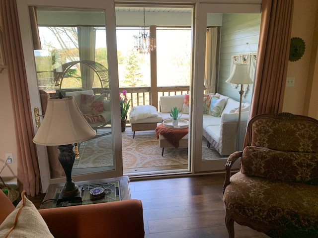 doorway with healthy amount of natural light, a chandelier, and wood finished floors