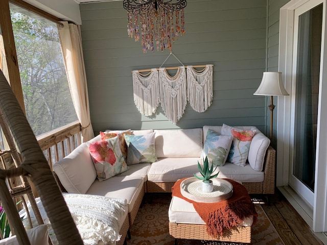 living area featuring a chandelier, wood walls, and wood finished floors