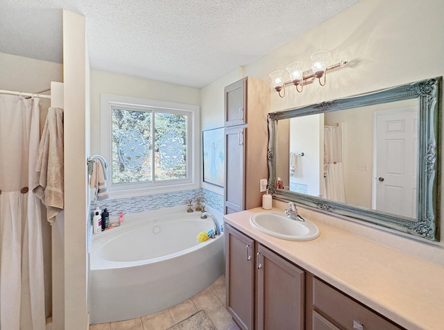 bathroom with a garden tub, vanity, a textured ceiling, and tile patterned flooring