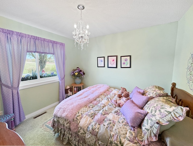 carpeted bedroom featuring a chandelier and baseboards
