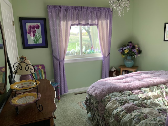 carpeted bedroom featuring baseboards and a chandelier