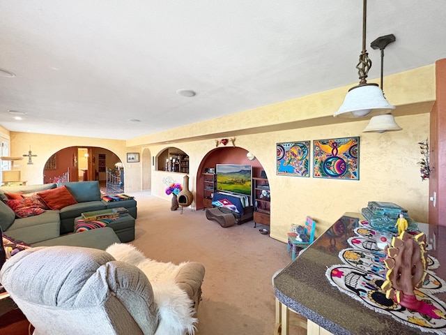 living area with carpet flooring and arched walkways