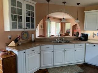 kitchen with dishwasher, glass insert cabinets, white cabinetry, decorative light fixtures, and a sink