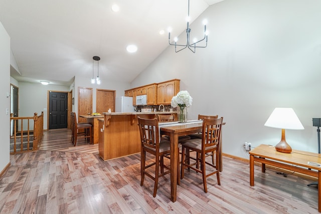 17081 Pheasant Meadow Ln SW, Prior Lake, MN 55372 - dining area featuring light wood finished floors, a chandelier, baseboards, high vaulted ceiling, and recessed lighting