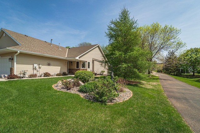 17081 Pheasant Meadow Ln SW, Prior Lake, MN 55372 - view of side of property featuring a lawn, an attached garage, and a shingled roof