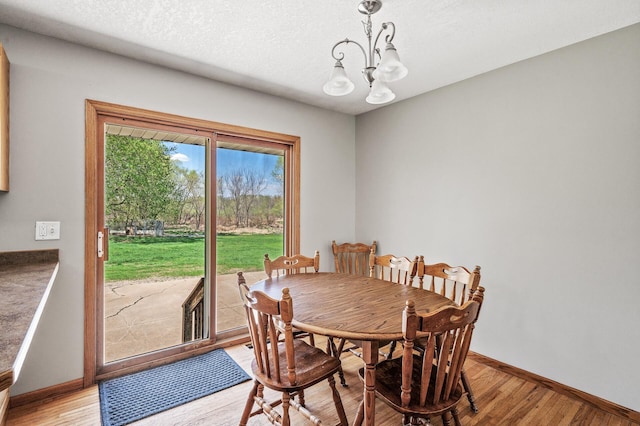 7349 Variolite Dr NW, Stanford Twp, MN 55398 - dining room featuring a chandelier, light wood-style floors, baseboards, and a textured ceiling