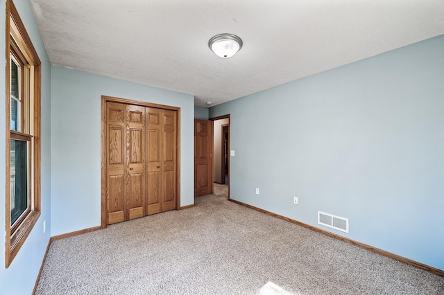 7349 Variolite Dr NW, Stanford Twp, MN 55398 - unfurnished bedroom with light carpet, baseboards, a closet, and a textured ceiling