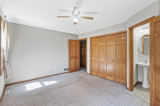 7349 Variolite Dr NW, Stanford Twp, MN 55398 - unfurnished bedroom featuring light carpet, a closet, baseboards, ceiling fan, and ensuite bathroom