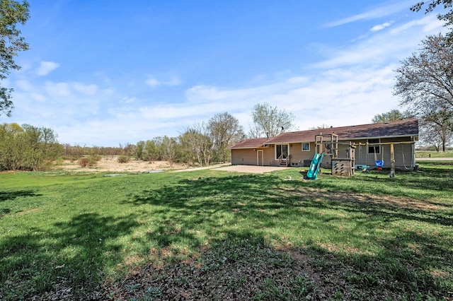 7349 Variolite Dr NW, Stanford Twp, MN 55398 - view of grassy yard featuring an attached garage, a patio, a playground, and driveway