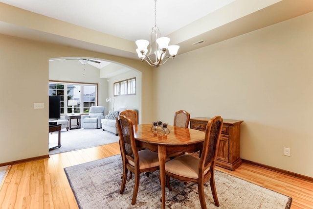 8713 9th Pl N, Lake Elmo, MN 55042 - dining space with arched walkways, light wood-type flooring, a chandelier, and a ceiling fan