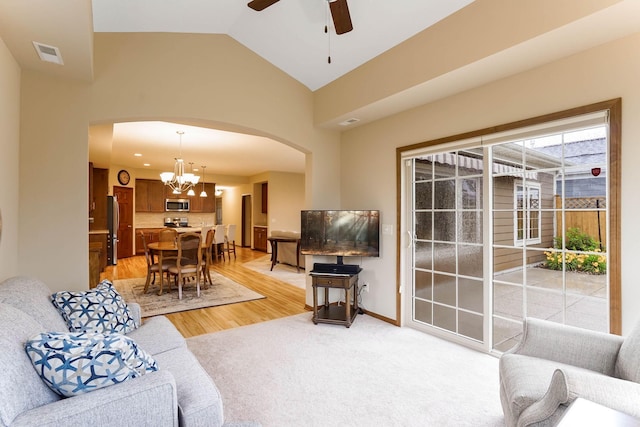 8713 9th Pl N, Lake Elmo, MN 55042 - living area featuring arched walkways, a chandelier, a ceiling fan, light wood finished floors, and high vaulted ceiling