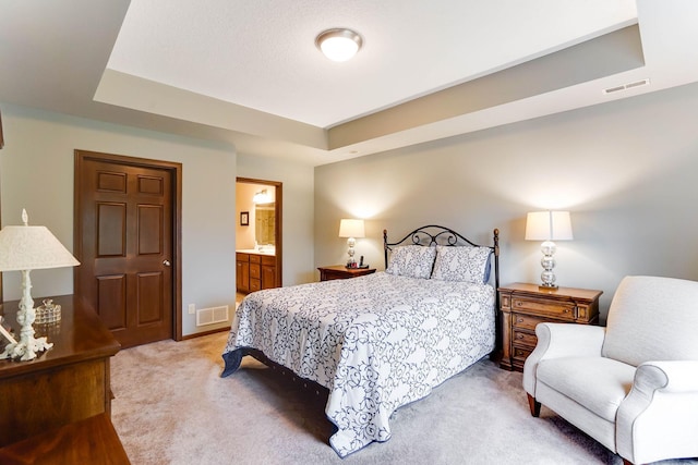 8713 9th Pl N, Lake Elmo, MN 55042 - bedroom featuring light colored carpet, a tray ceiling, and ensuite bathroom
