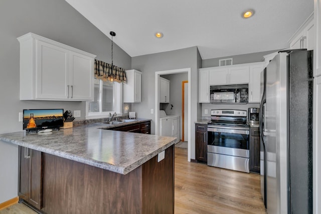223 Glenview Loop, Saint Cloud, MN 56303 - kitchen featuring appliances with stainless steel finishes, washer and dryer, a peninsula, a sink, and light wood-style floors
