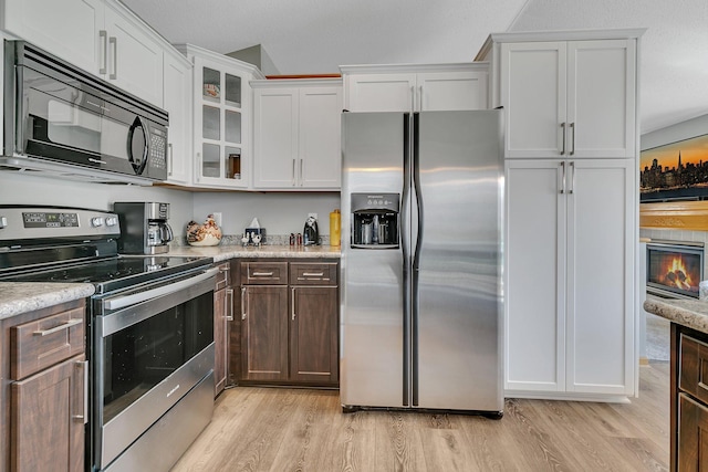 223 Glenview Loop, Saint Cloud, MN 56303 - kitchen with appliances with stainless steel finishes, light wood-type flooring, white cabinets, glass insert cabinets, and light stone countertops
