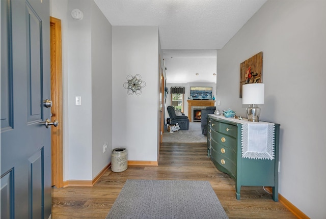223 Glenview Loop, Saint Cloud, MN 56303 - entrance foyer featuring a lit fireplace, wood finished floors, baseboards, and a textured ceiling