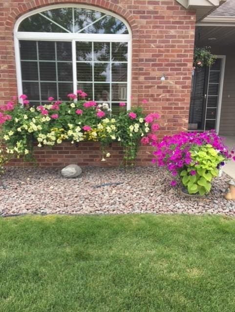223 Glenview Loop, Saint Cloud, MN 56303 - doorway to property featuring brick siding and a lawn