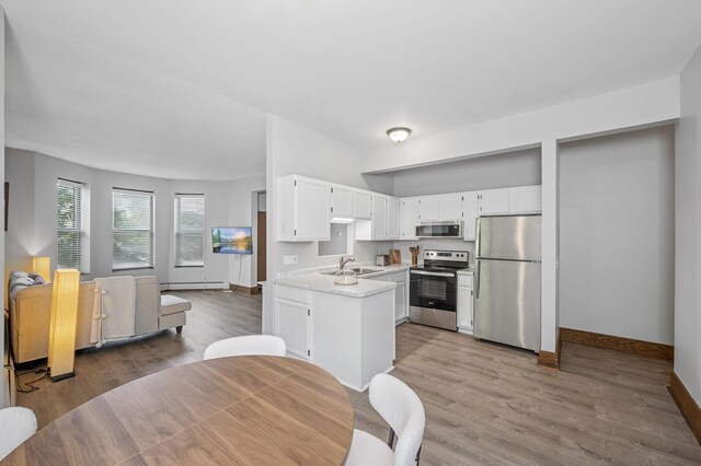 1811 Elliot Ave Unit 2, Minneapolis, MN 55404 - kitchen featuring appliances with stainless steel finishes, a sink, a baseboard heating unit, light countertops, and baseboards