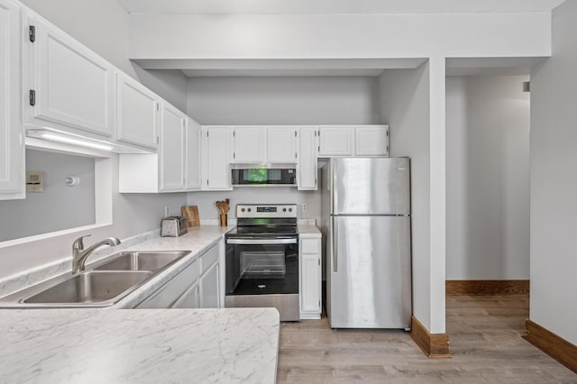 1811 Elliot Ave Unit 2, Minneapolis, MN 55404 - kitchen with appliances with stainless steel finishes, a sink, white cabinets, light countertops, and light wood-style floors