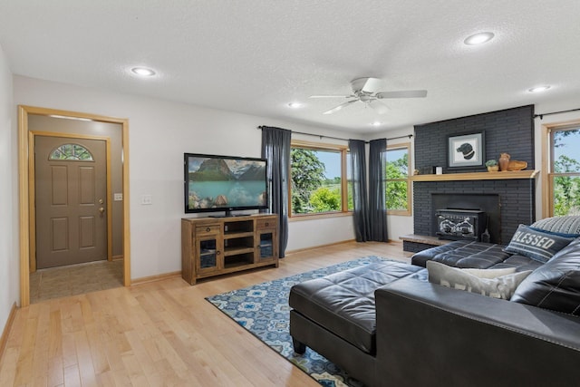 14530 Jonathan Carver Pkwy, Carver, MN 55315 - living room with a ceiling fan, wood finished floors, baseboards, a textured ceiling, and a brick fireplace