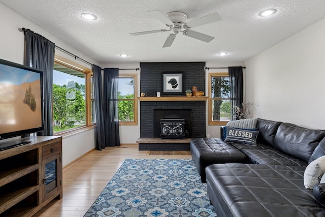 14530 Jonathan Carver Pkwy, Carver, MN 55315 - living area with a textured ceiling, plenty of natural light, light wood-style floors, a ceiling fan, and a fireplace