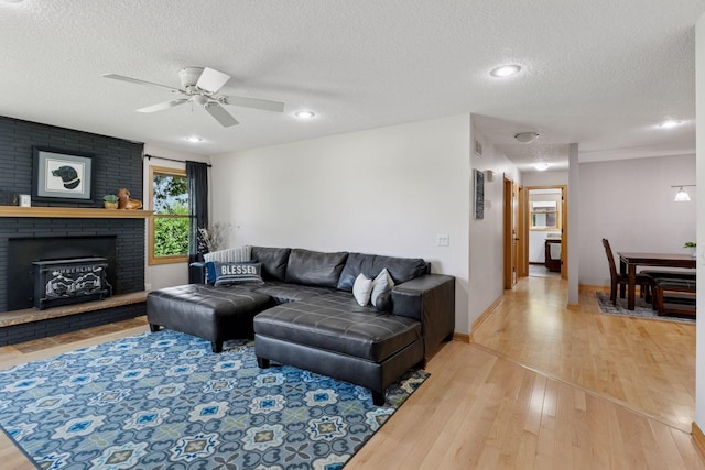 14530 Jonathan Carver Pkwy, Carver, MN 55315 - living room with light wood-type flooring, a textured ceiling, a ceiling fan, a fireplace, and recessed lighting