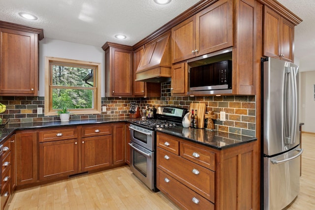 14530 Jonathan Carver Pkwy, Carver, MN 55315 - kitchen with appliances with stainless steel finishes, custom exhaust hood, light wood-style flooring, brown cabinetry, and a textured ceiling