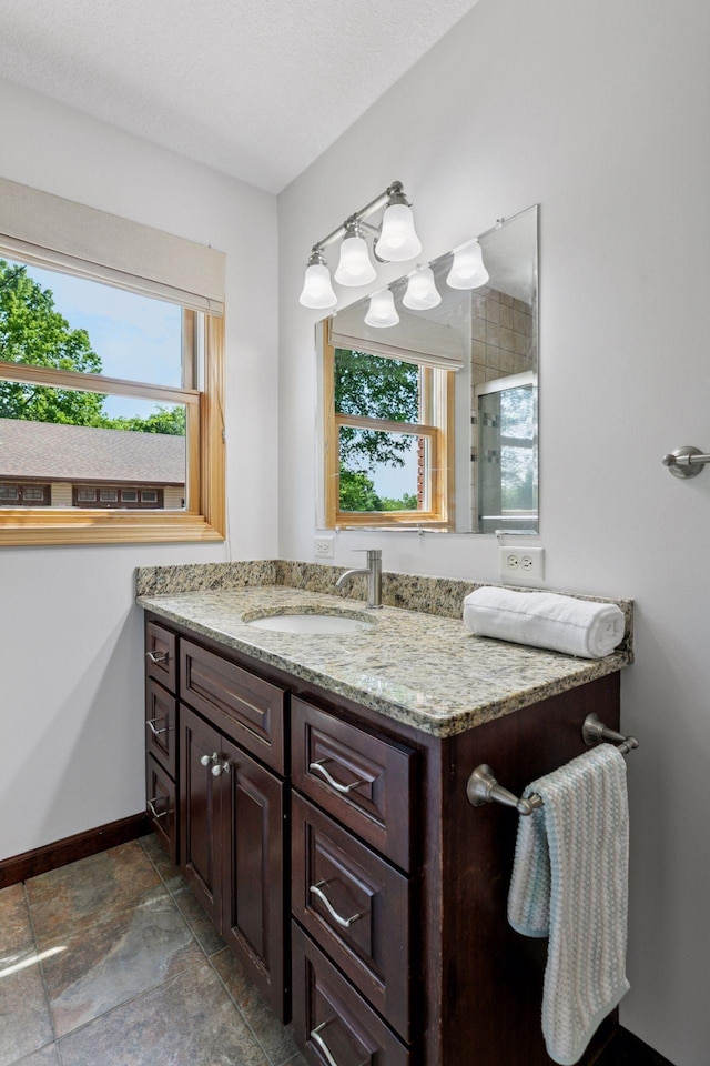 14530 Jonathan Carver Pkwy, Carver, MN 55315 - bathroom featuring vanity, baseboards, stone finish flooring, and a shower