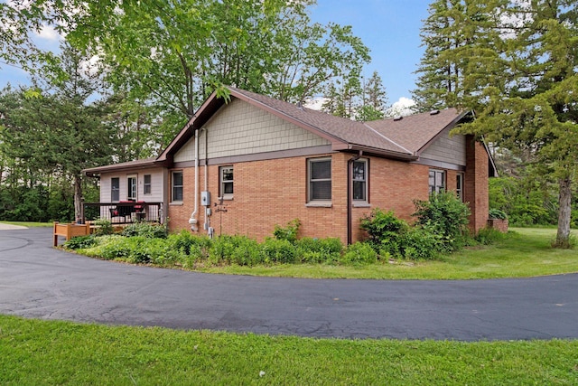 14530 Jonathan Carver Pkwy, Carver, MN 55315 - view of side of property with brick siding, a wooden deck, and a yard
