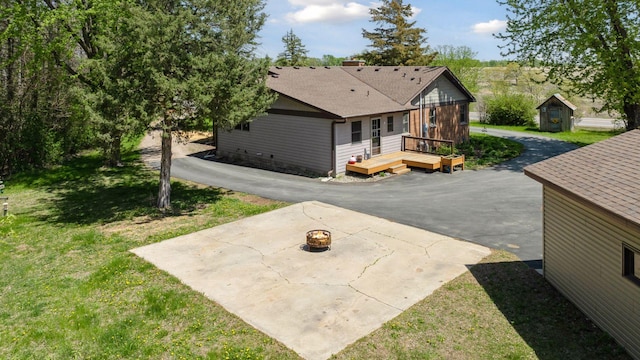 14530 Jonathan Carver Pkwy, Carver, MN 55315 - rear view of property featuring a wooden deck, a patio, a fire pit, a yard, and a shingled roof