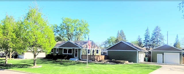 view of front facade featuring a front yard, a garage, and an outdoor structure