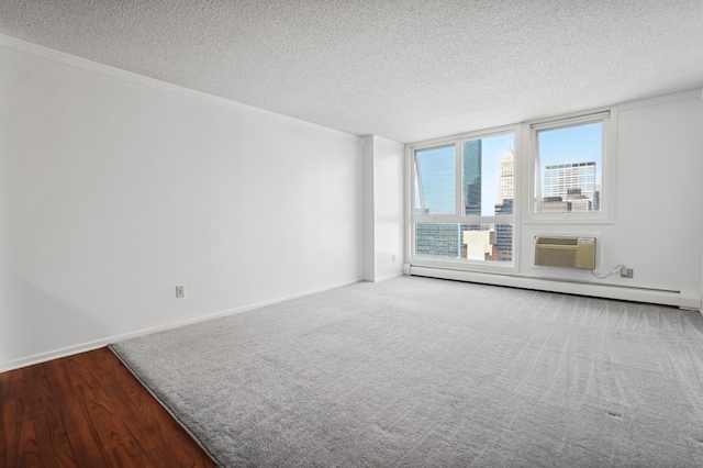 spare room with a textured ceiling, a baseboard radiator, ornamental molding, and a wall mounted AC