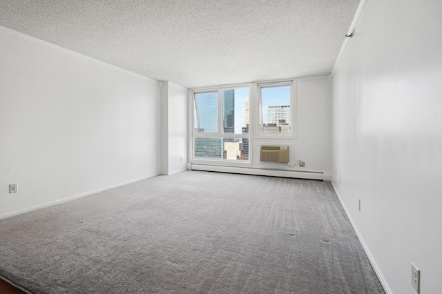 empty room with a baseboard heating unit, a textured ceiling, crown molding, carpet, and an AC wall unit