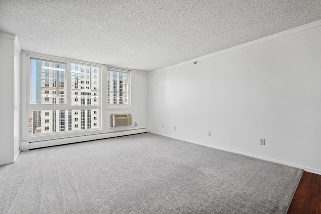 unfurnished room with a baseboard heating unit, a textured ceiling, carpet, a wall mounted air conditioner, and crown molding