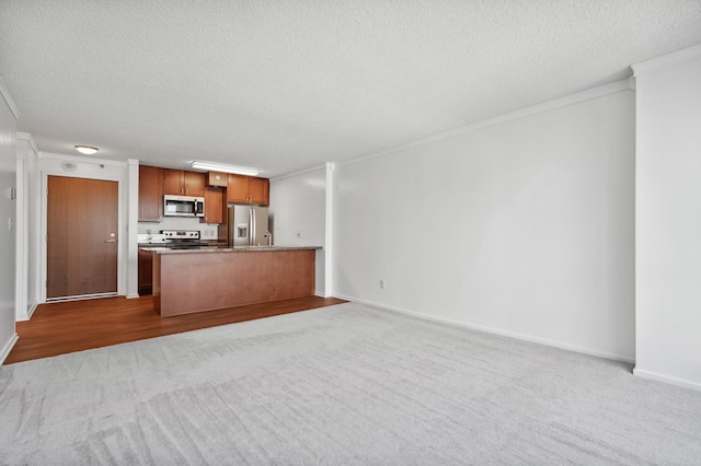 unfurnished living room featuring crown molding, carpet floors, a textured ceiling, and baseboards