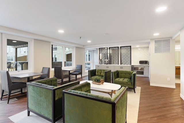 living area with recessed lighting, wood finished floors, and baseboards
