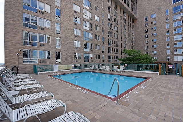 community pool featuring fence and a patio area